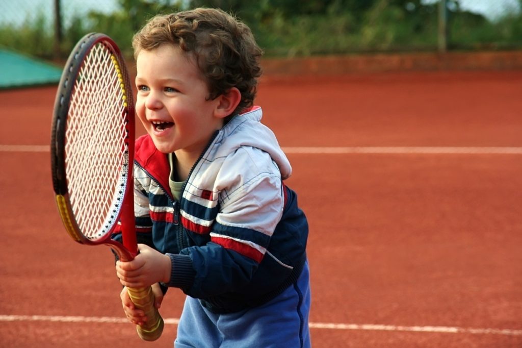 ребенок с ракеткой для большого тенниса